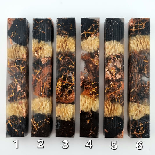 Six pen blanks with layered black, gold, and beige patterns on a white background.